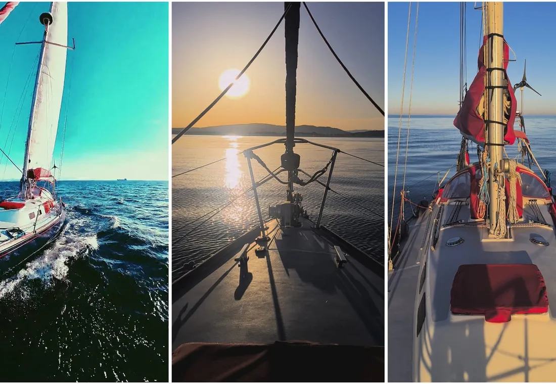 Un velero navegando en un mar tranquilo, bajo un cielo teñido de rojo y naranja por el atardecer.