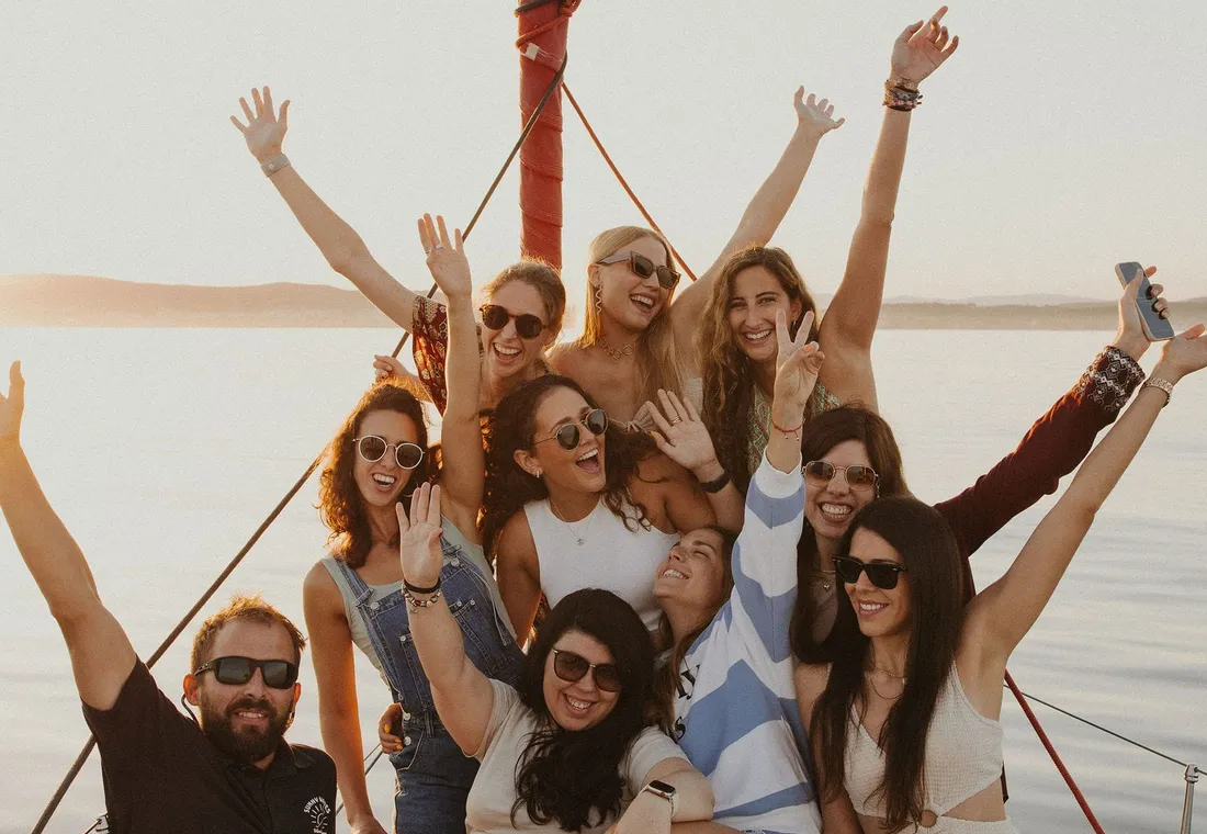 Grupo de amigos en Velero Assol en Sotogrande, Alquiler de velero privado al atardecer del velero rojo