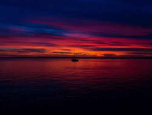 Un horizonte donde el mar y el cielo se funden bajo un atardecer de tonos rosados y púrpuras.