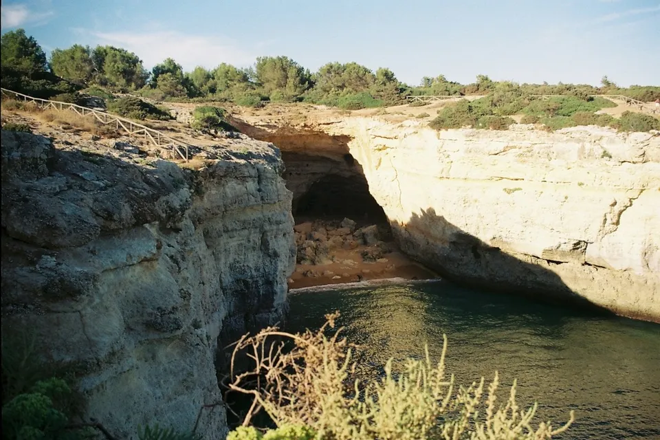 Cliffs and a cave entrance on the coast of the Algarve. Photo via Unsplash