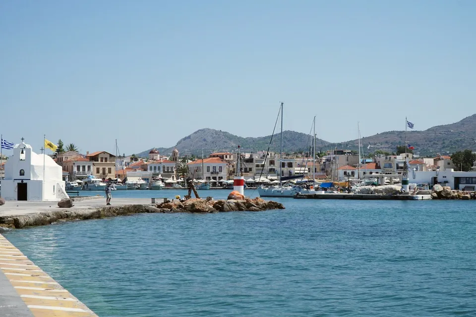 A small harbour on a Greek island, with a white chapel and boats. Photo via Unsplash