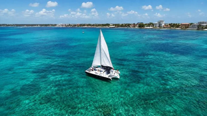 A catamaran sailing over turquoise water in Belize