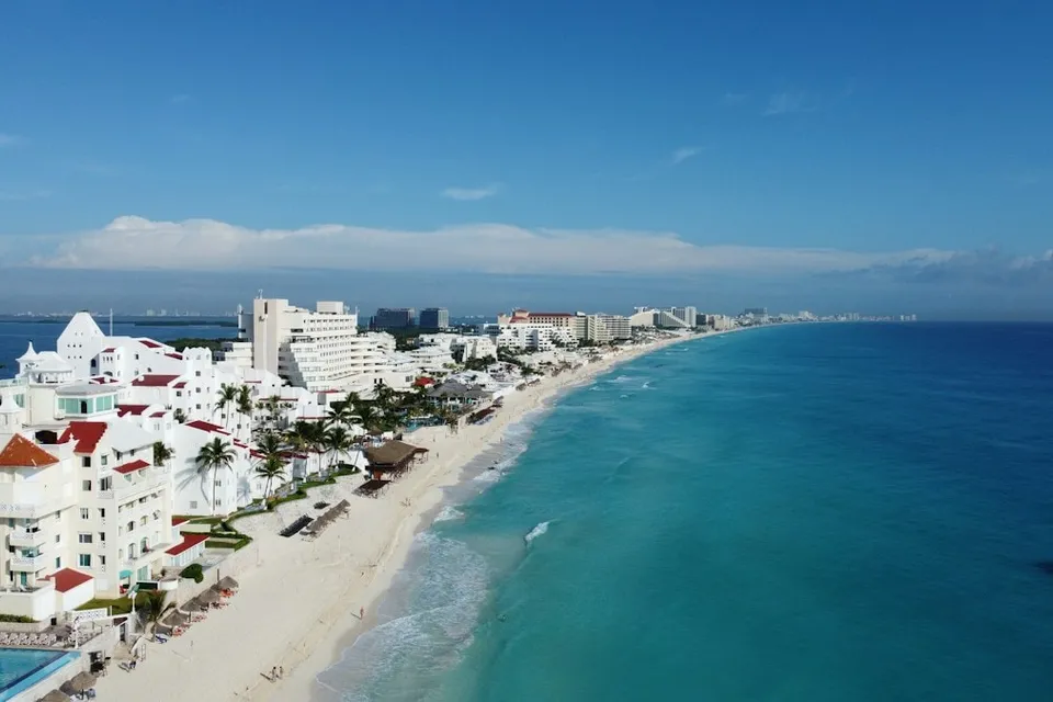 Aerial view of a beach and the city of Cancún. Photo via Unsplash