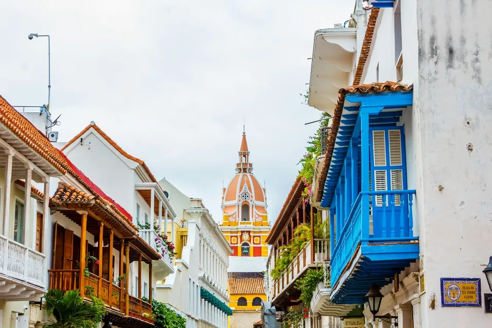A street with colonial houses and a cathedral tower in Cartagena. Photo via Unsplash