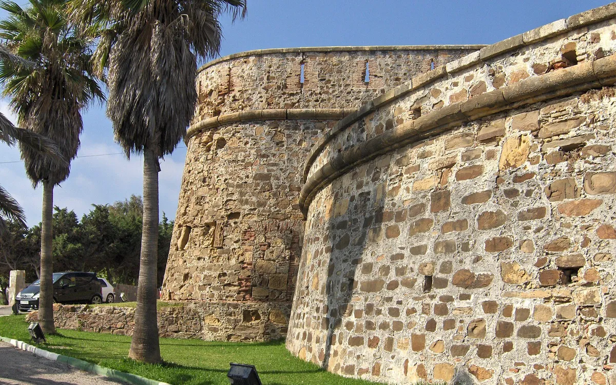 Bastion of Castillo de la Duquesa with palm trees