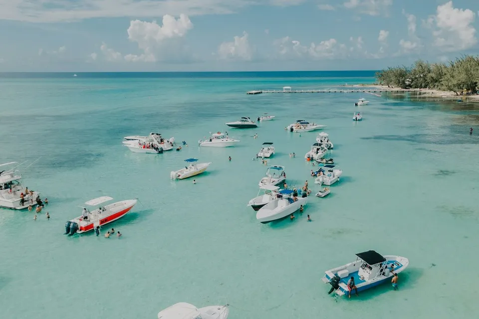 Boats gathered at the shallow Stingray City sandbar, Grand Cayman. Photo via Unsplash
