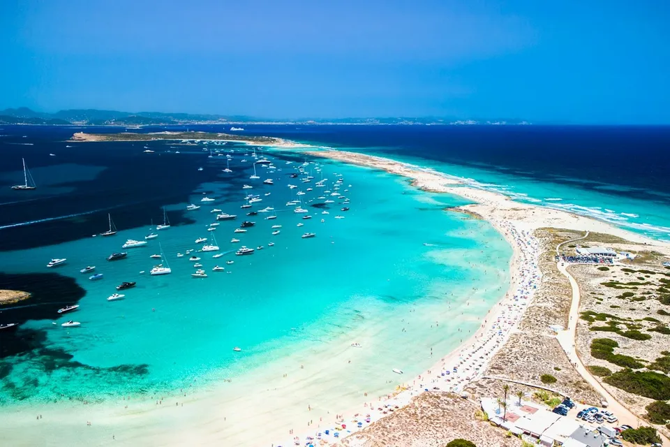 Boats anchored off a white sand beach in Formentera. Photo via Unsplash