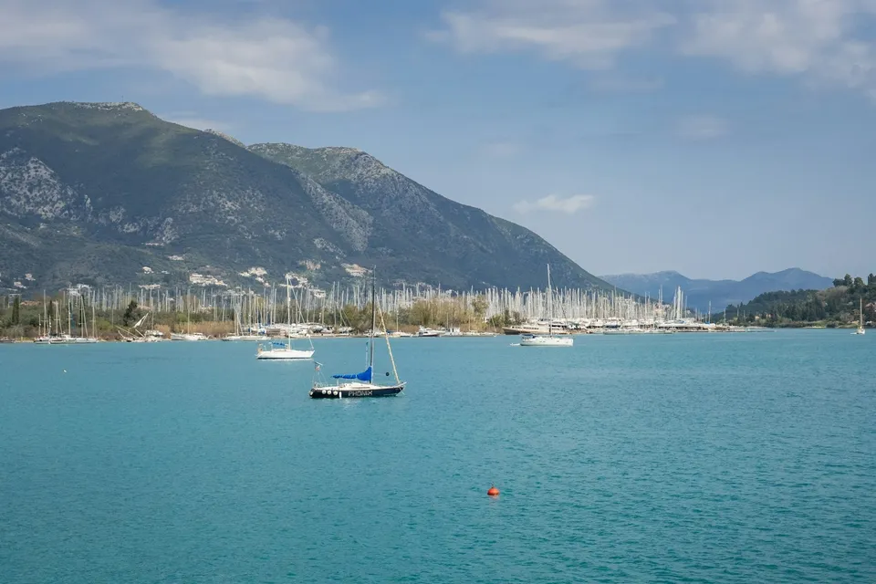 Sailboats in a bay with mountains in the Ionian Sea. Photo via Unsplash