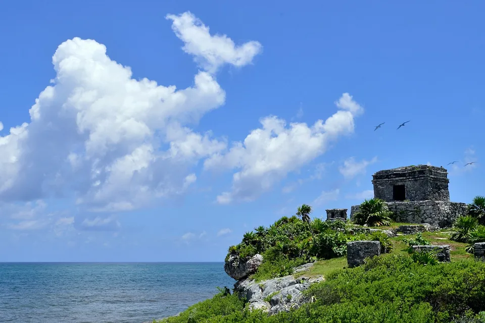 The Tulum castle on a green cliff above the sea. Photo via Unsplash