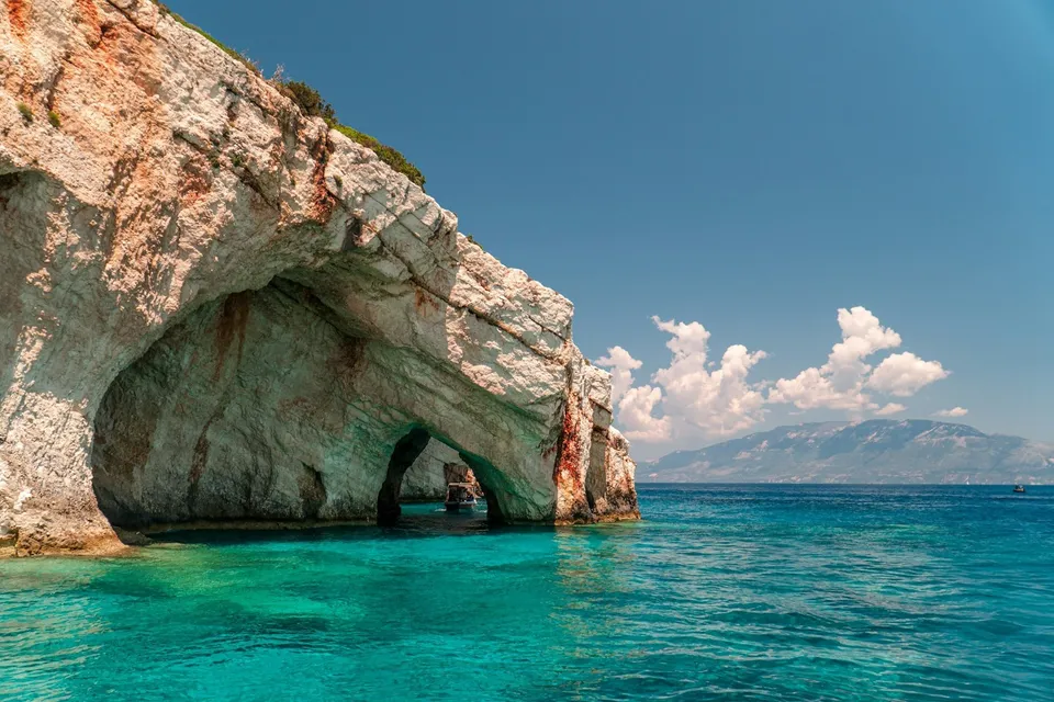 A rock arch over turquoise water, Zakynthos. Photo via Unsplash