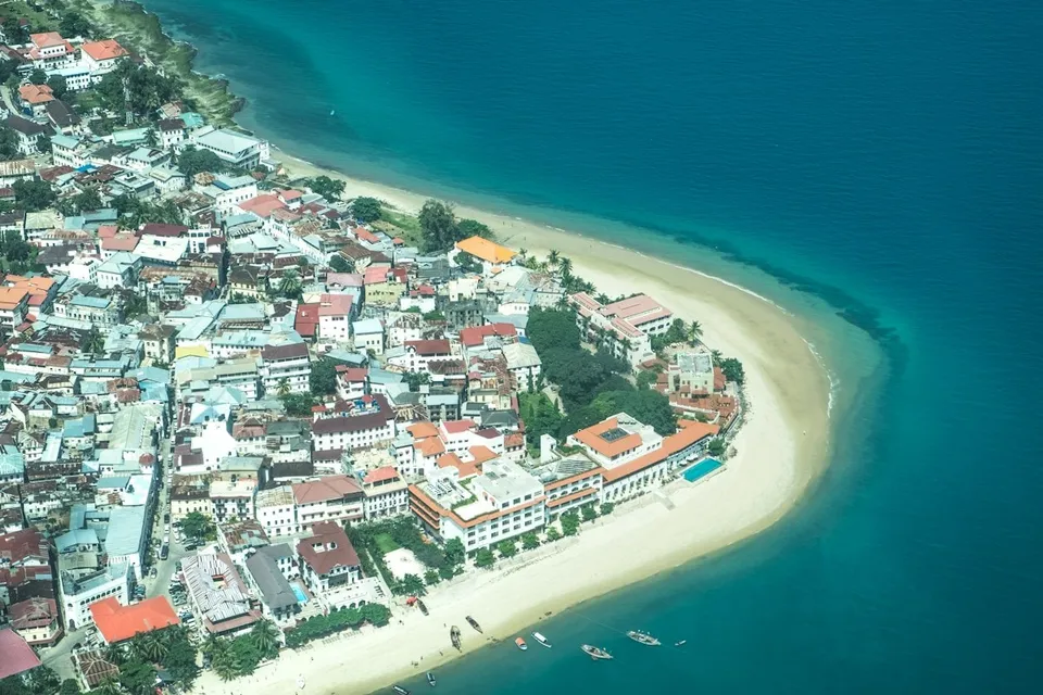 Aerial view of a coastal village and turquoise water in Zanzibar. Photo via Unsplash