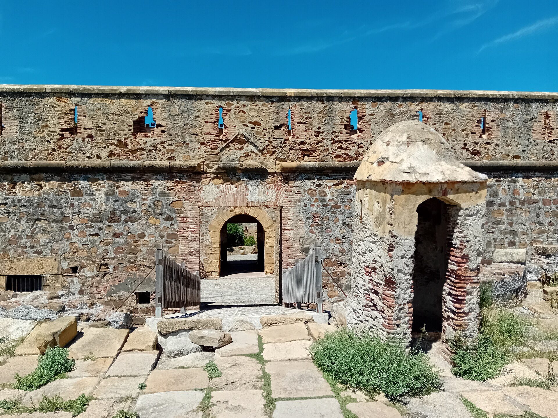 Inner courtyard of Castillo de la Duquesa with a sentry box and a brick staircase